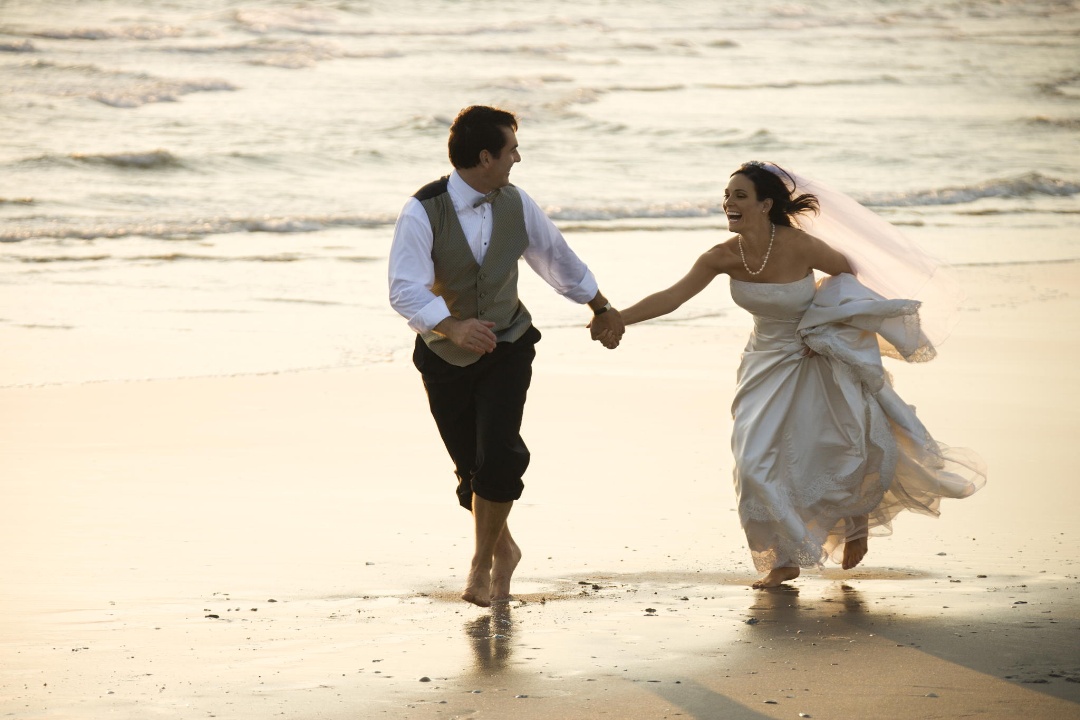 Bride and groom on beach.