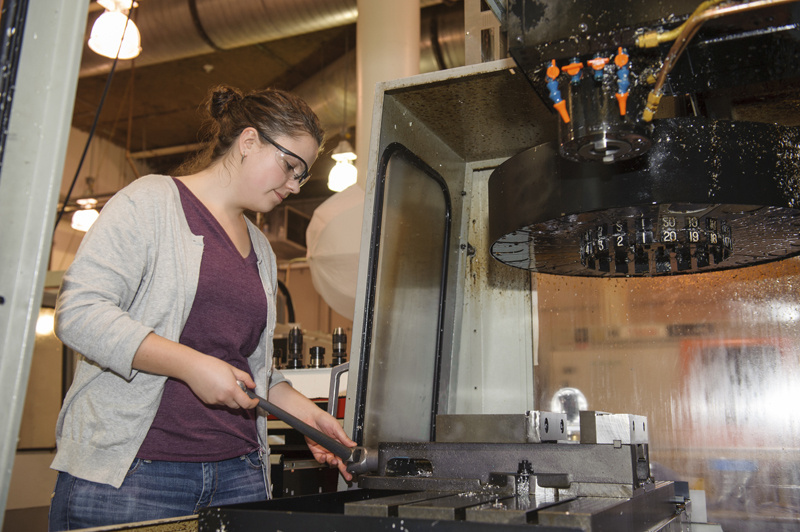 Woman engineer working on machine.