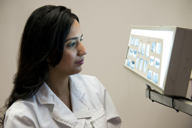 Dentist looking at xrays.