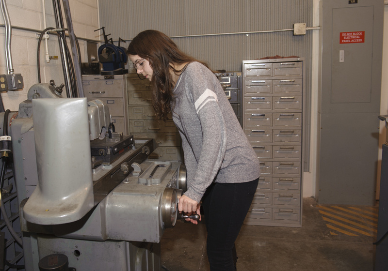 Woman engineer working a machine.