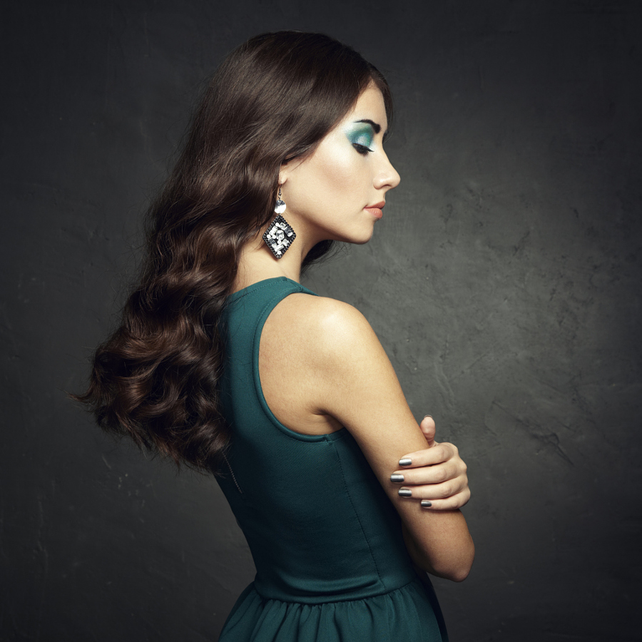 Portrait of beautiful brunette woman in green dress