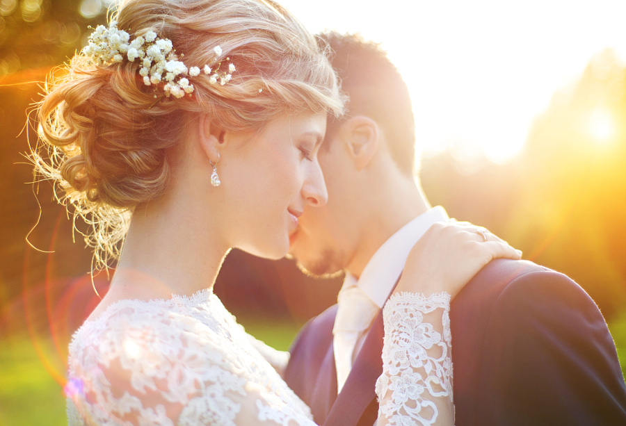 Young wedding couple enjoying romantic moments outside on a summer meadow