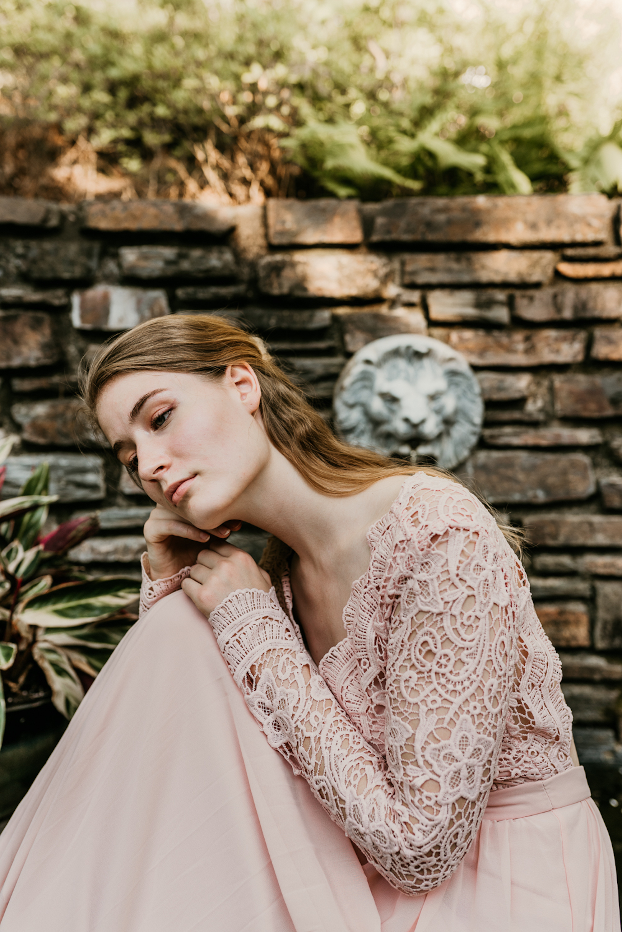 Caucasian woman in a pink dress sitting outside