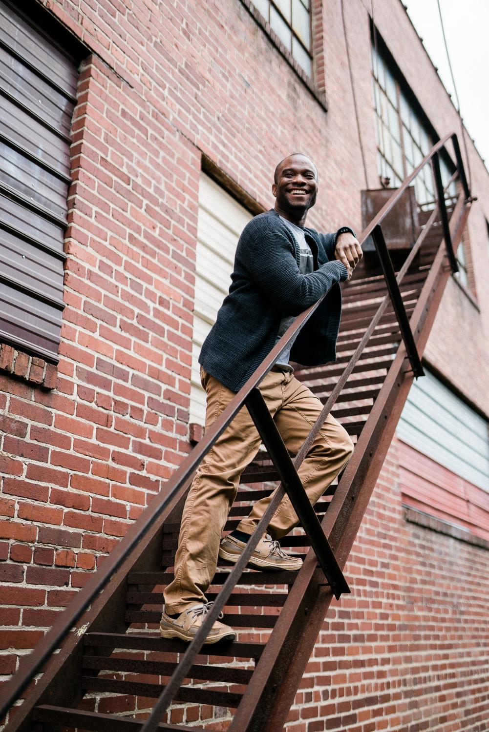 professional photographer Jason Hampden on a fire escape with a brick wall