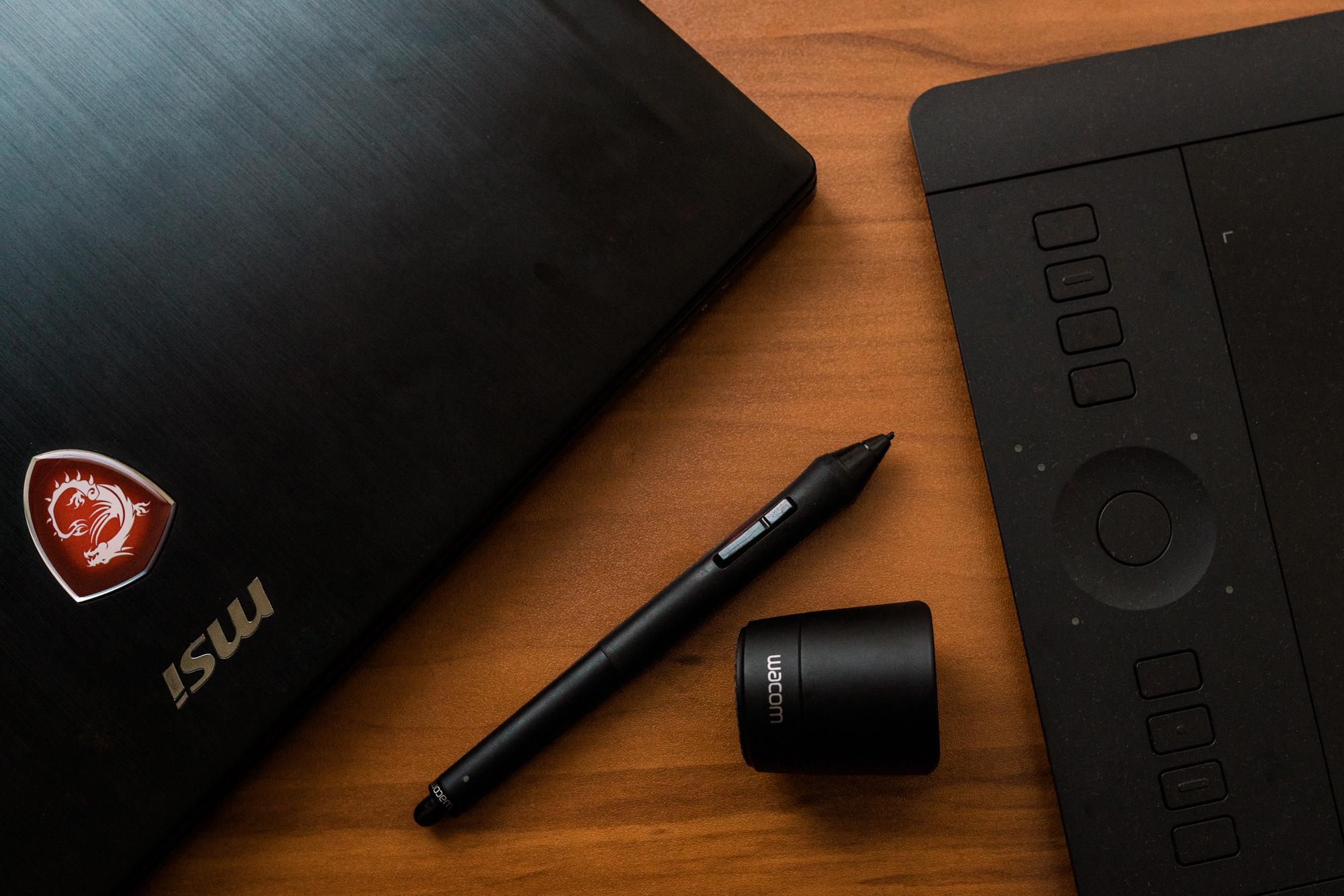 Computer and pen on a wooden table