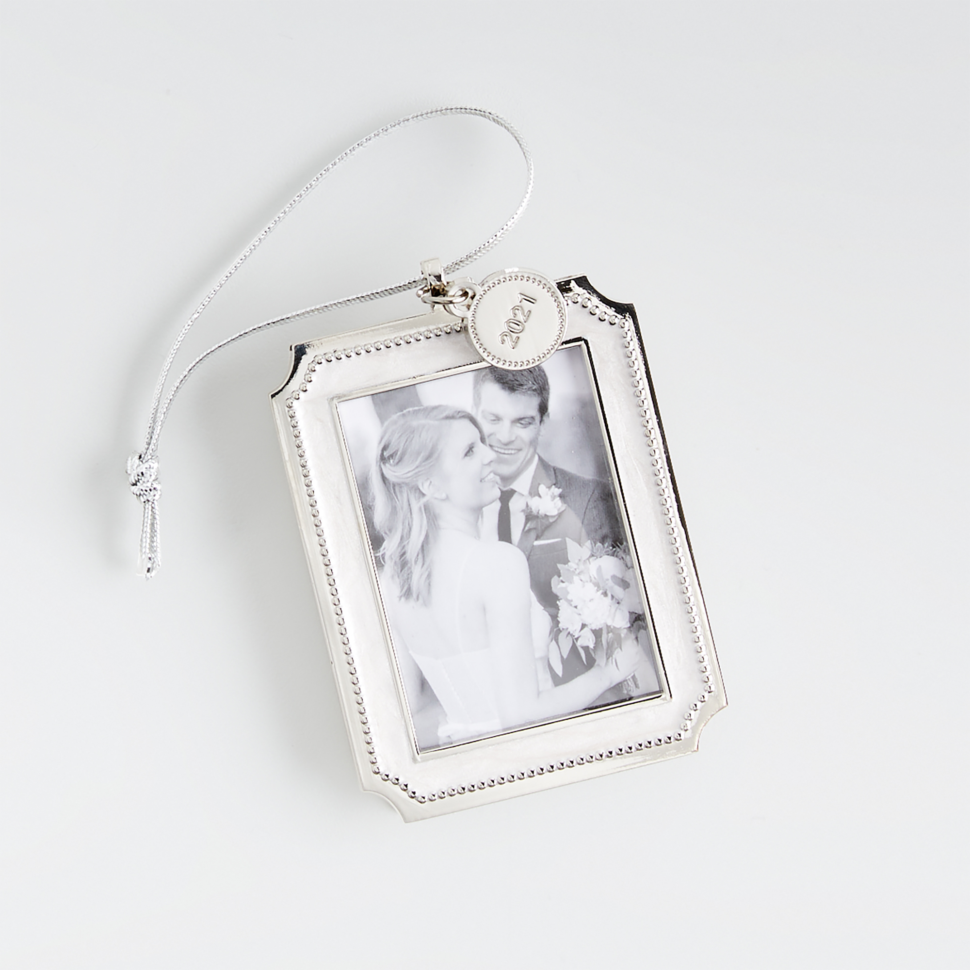 A christmas ornament picture frame with a wedding photo in it