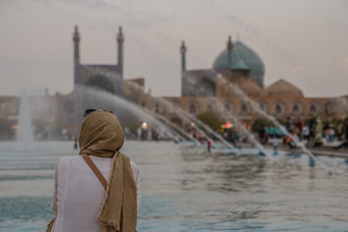 Tu?ba Din facing a fountain with the historic Shah Mosque in the background at Naqsh-e Jahan Square, Isfahan.
