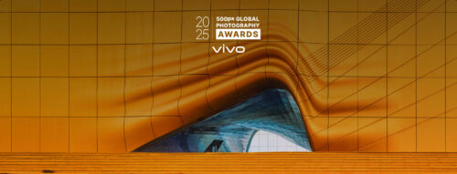Dynamic architectural structure with orange panels and sweeping lines, representing the 500px Global Photography Awards 2025.
