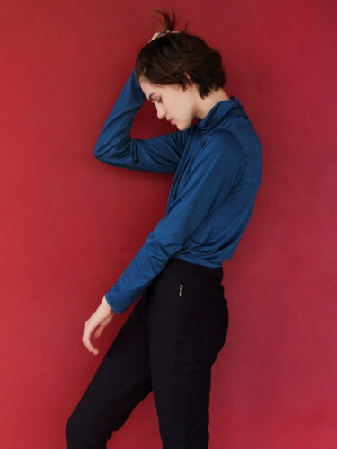 Portrait of a woman in a minimalist studio setting, illustrating focus and clarity to streamline your workflow and reduce creative distractions.