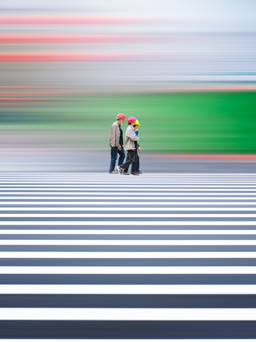 Capturing movement in photos using a panning technique with sharp pedestrians walking across a crosswalk and blurred colorful background