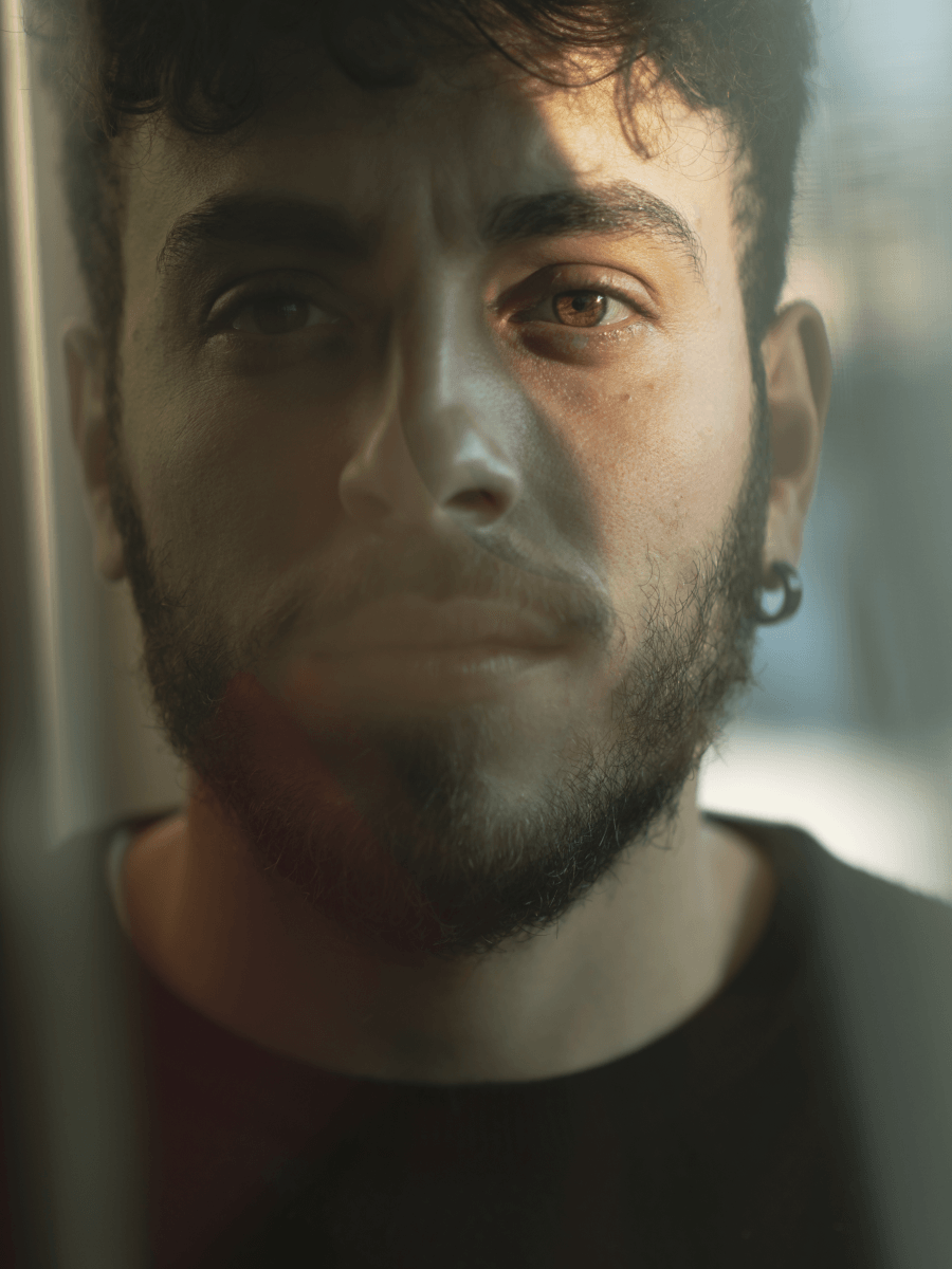 Close-up of a man’s face in soft directional window glow, an example of soft light portrait photography.