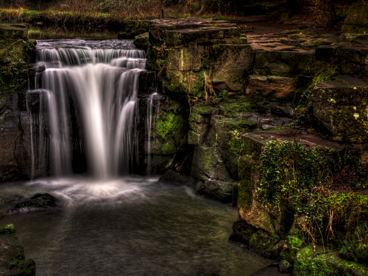 Long exposure waterfall flowing over mossy rocks, beautifully capturing movement in nature.