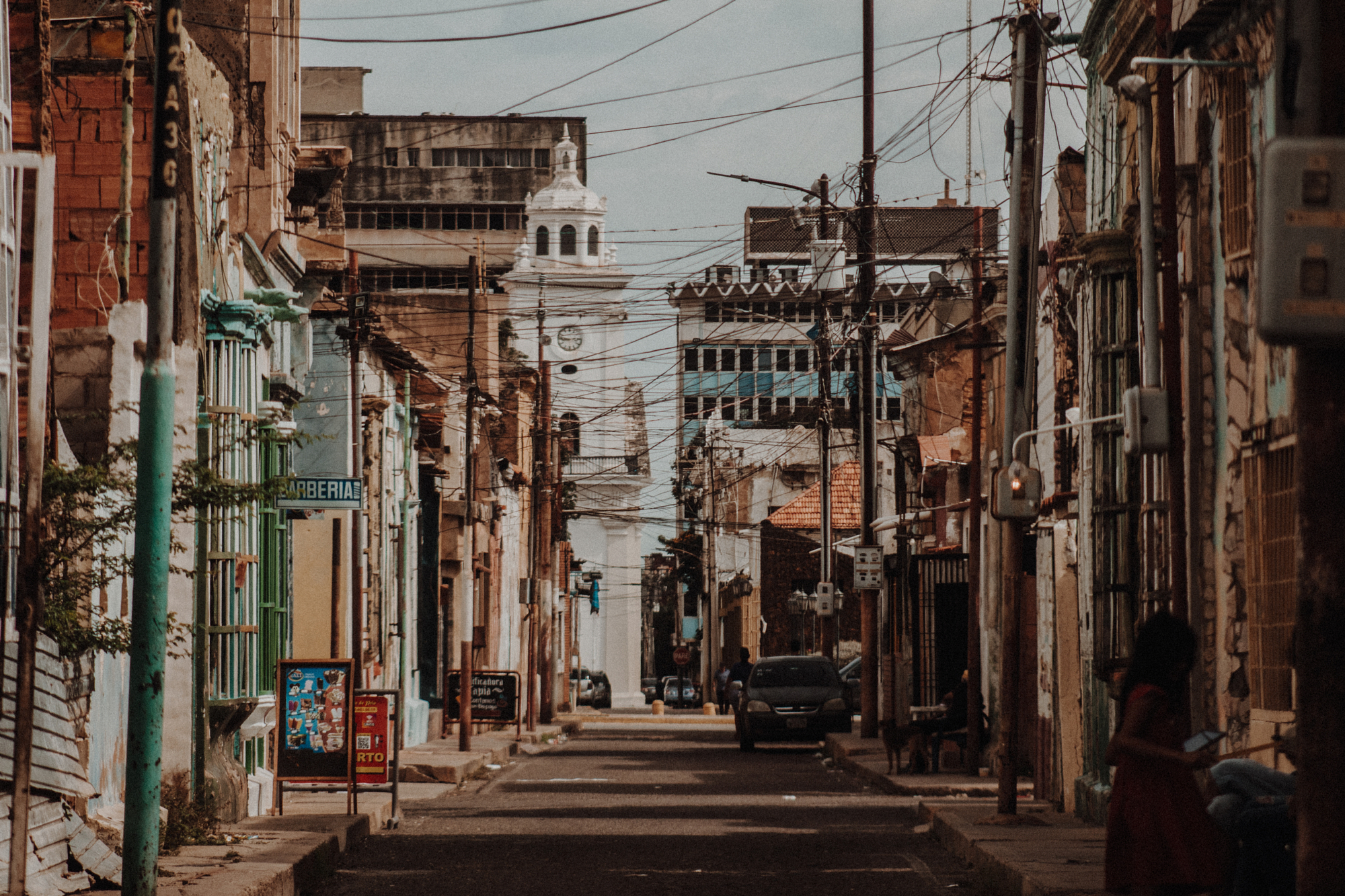 City street lined with buildings and overhead wires.