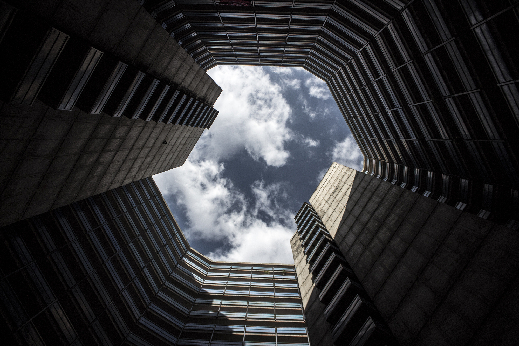 Sky viewed looking up from a geometric courtyard.