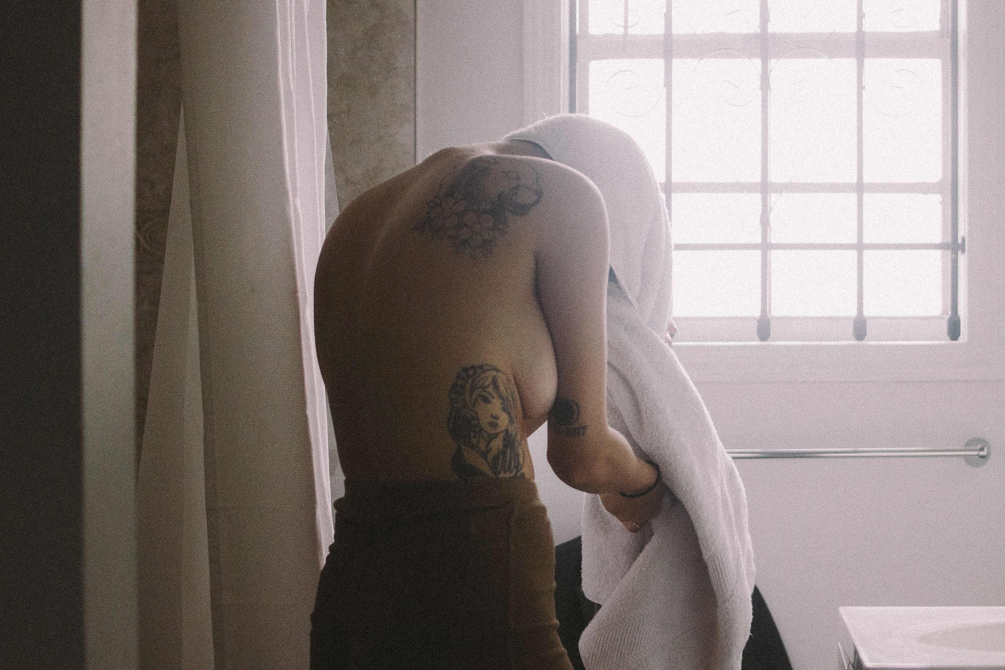 Woman drying their hair with a white towel.