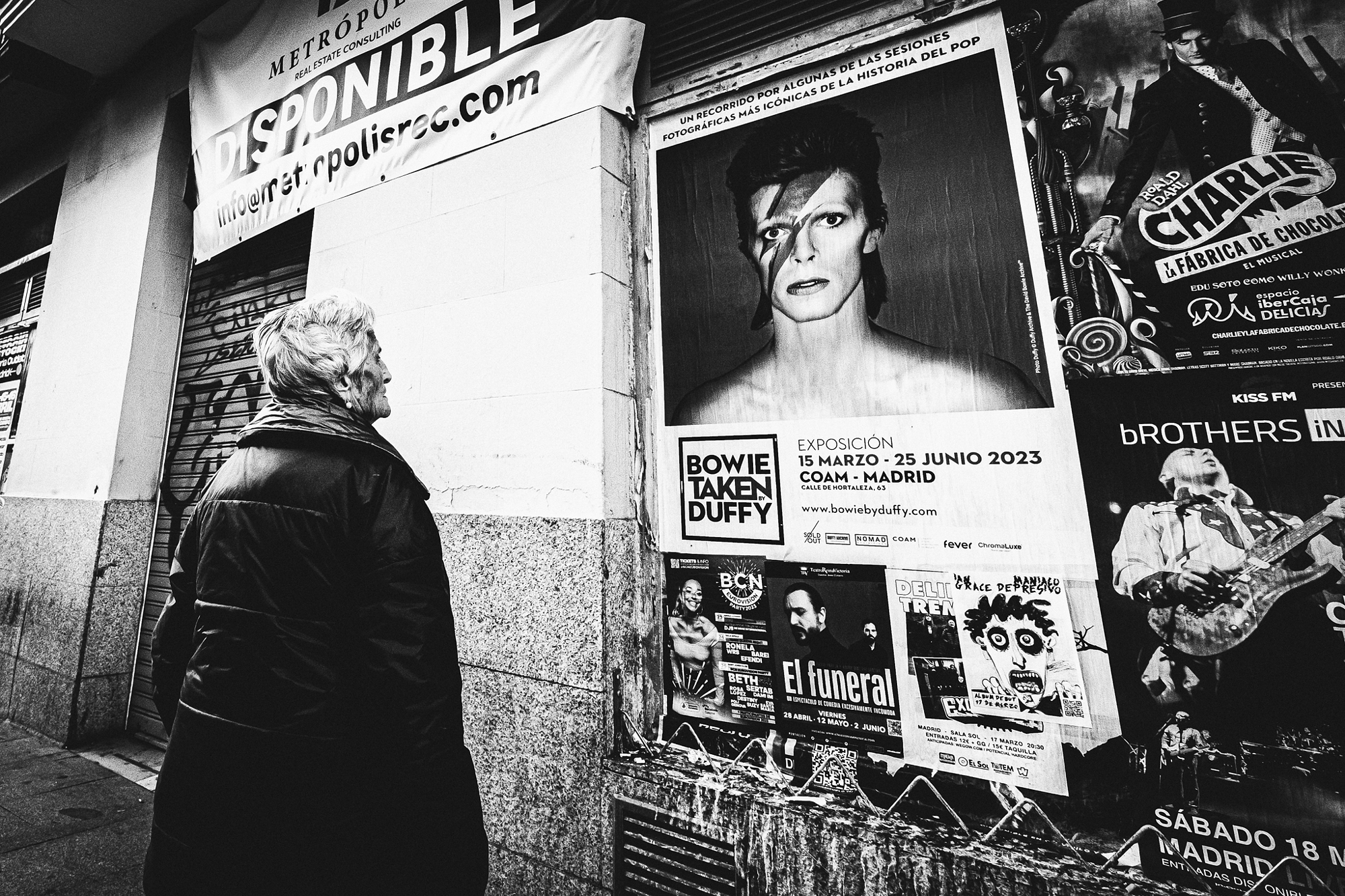Narrative-driven black and white street photography scene emphasizing shadows and composition.