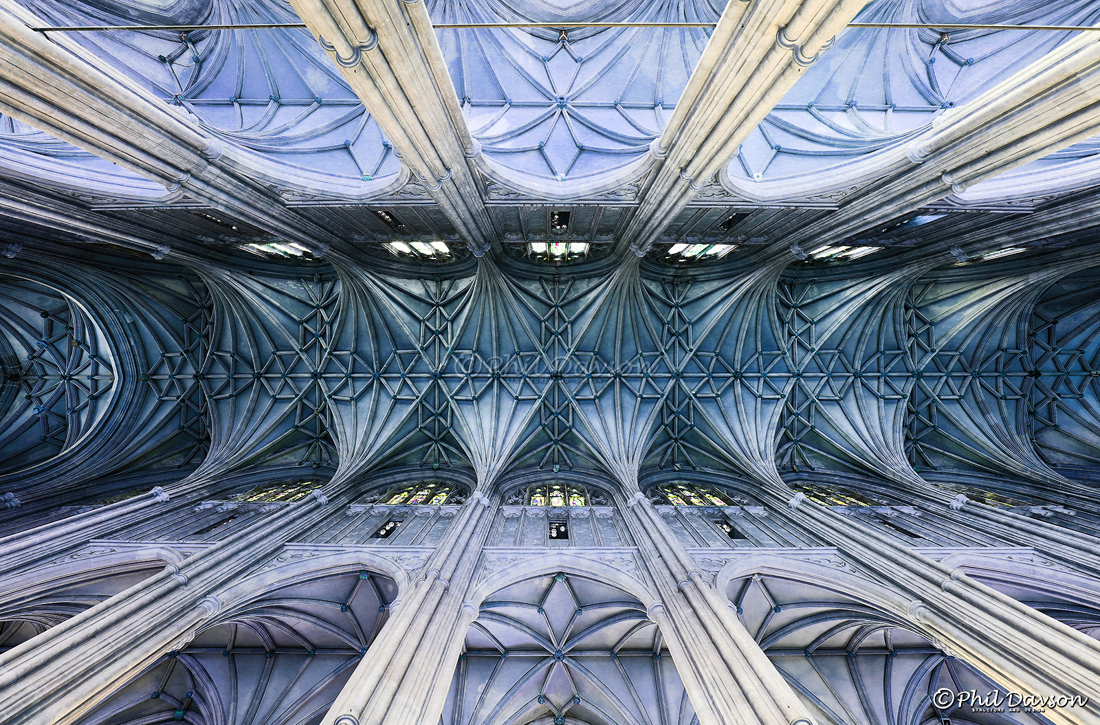 Wide-angle panorama of the historic Norman masonry ceiling inside Canterbury Cathedral in England.