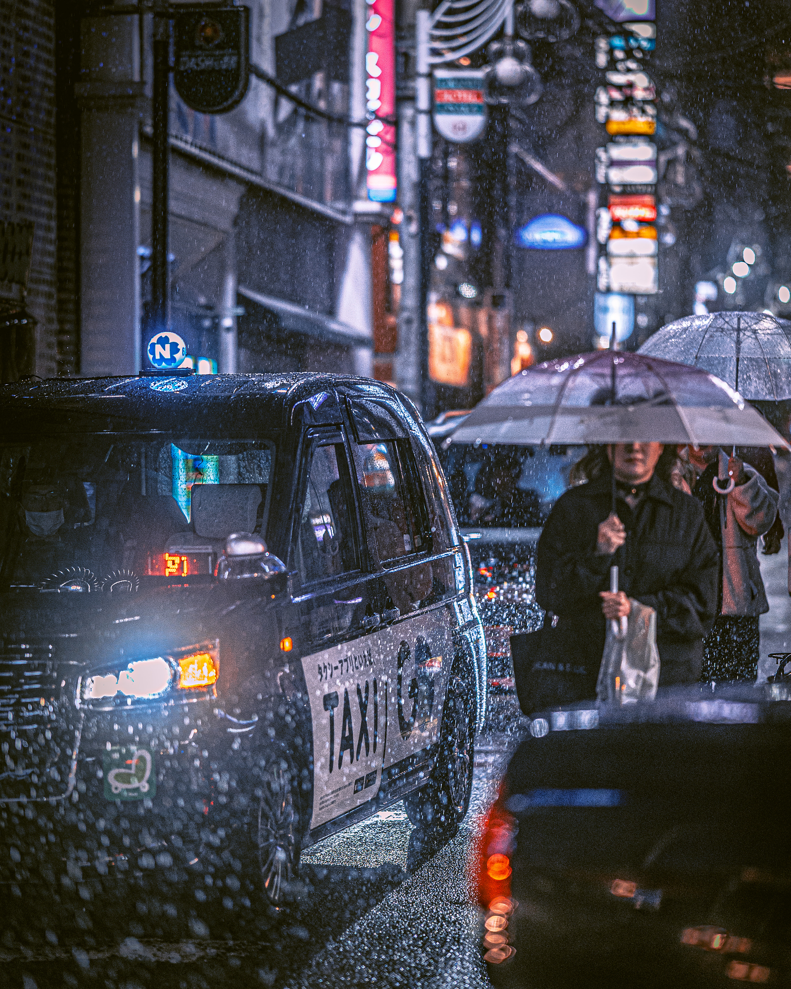 A Japanese taxi cab driving through a torrential downpour at night next to a pedestrian holding a clear umbrella, showcasing the moody, compressed layers of Masahiro Miyagi street photography.