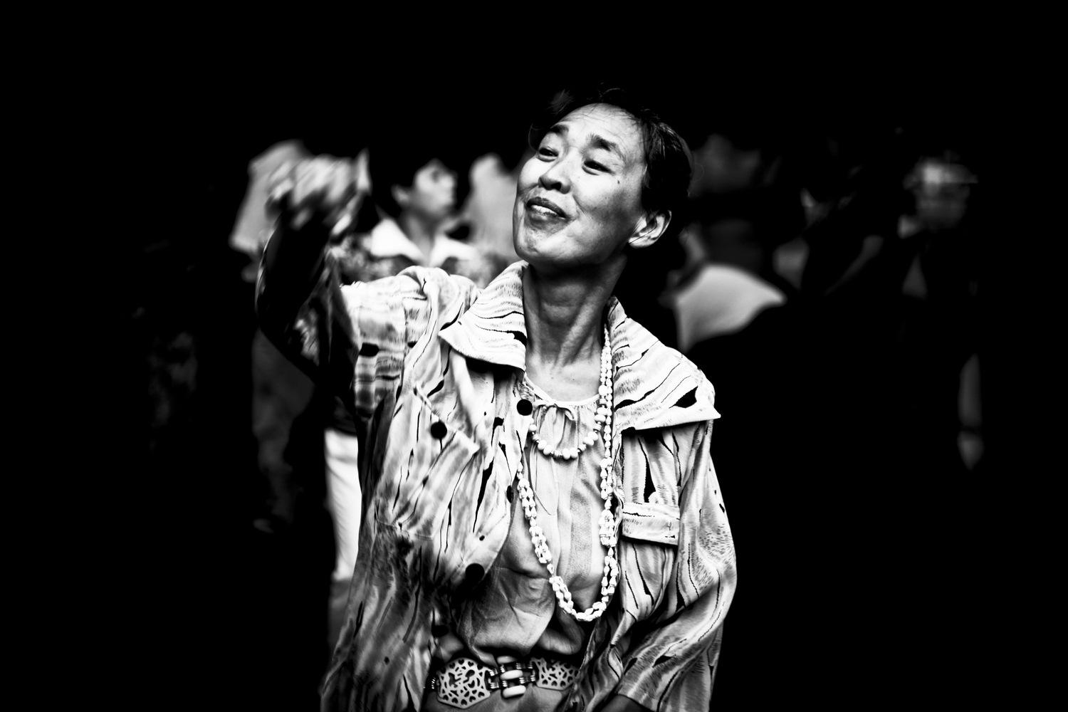 Expressive black and white street photography capturing a woman joyfully dancing