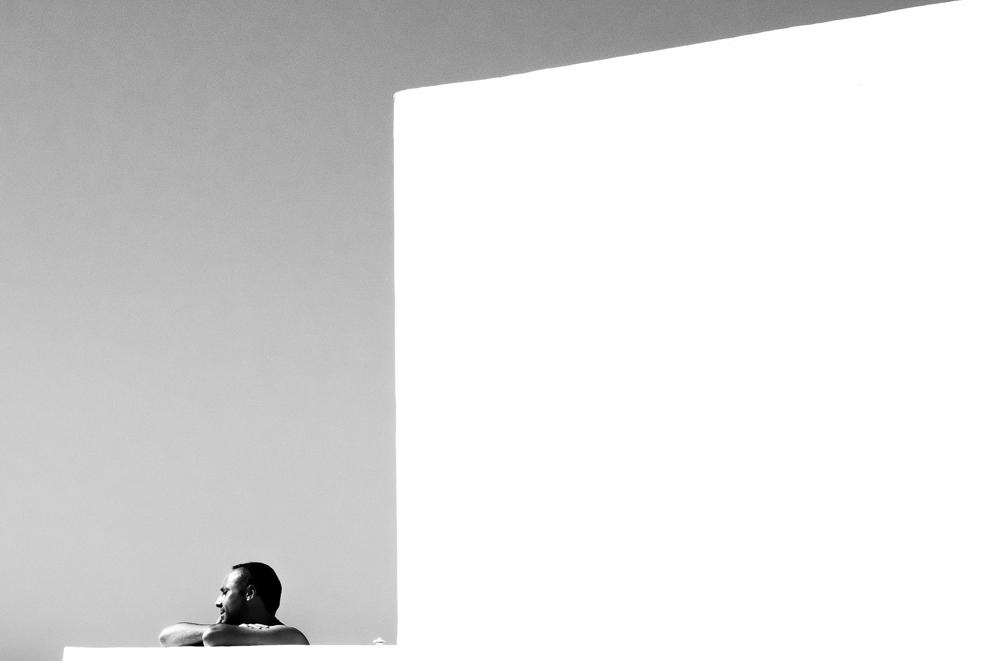 A relaxed human element captured in black and white street photography as someone enjoys the sun.