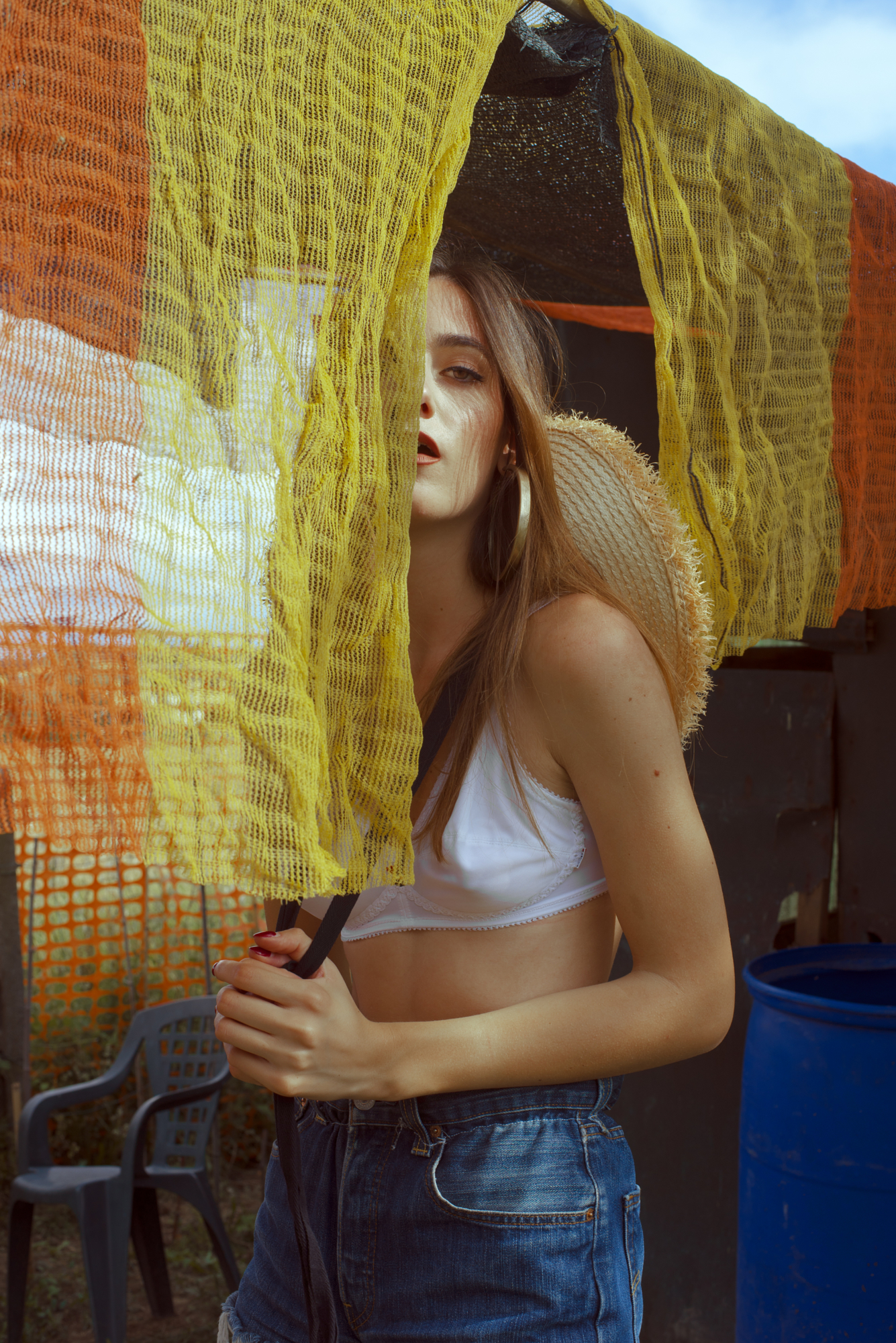 Outdoor editorial portrait showcasing tactile mesh fabric textures and warm sunlight contrast by photographer Micaela Belgiorno.