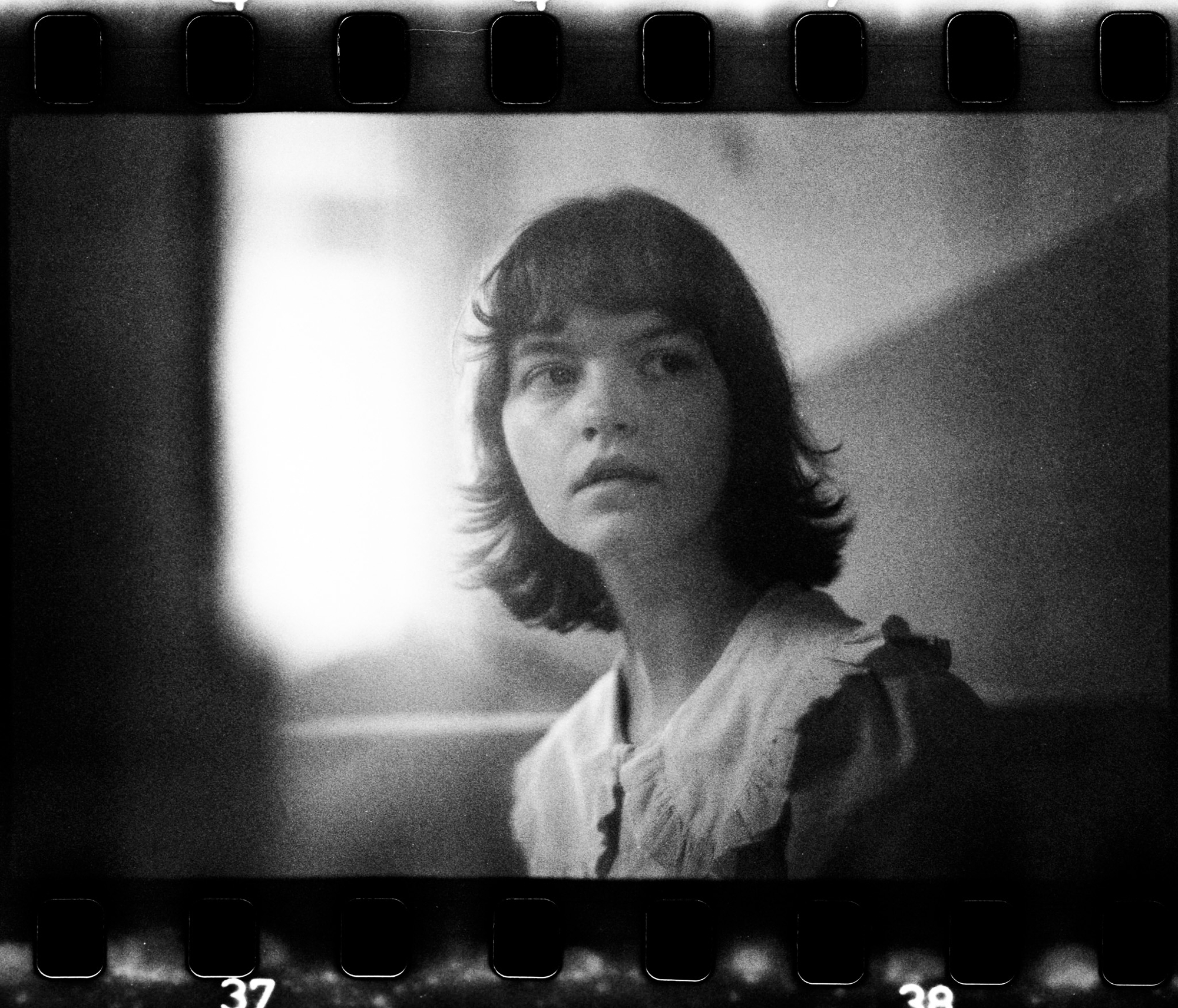 35mm analog film black and white portrait by Holger Nitschke featuring a woman illuminated by soft natural light.