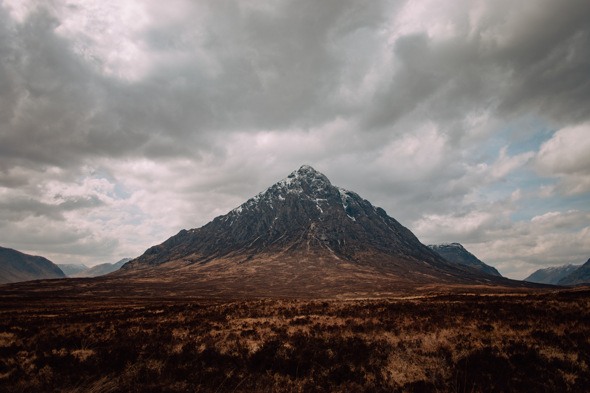 Moody landscape photograph of a dramatic mountain peak under cloudy skies from David Velez photography.