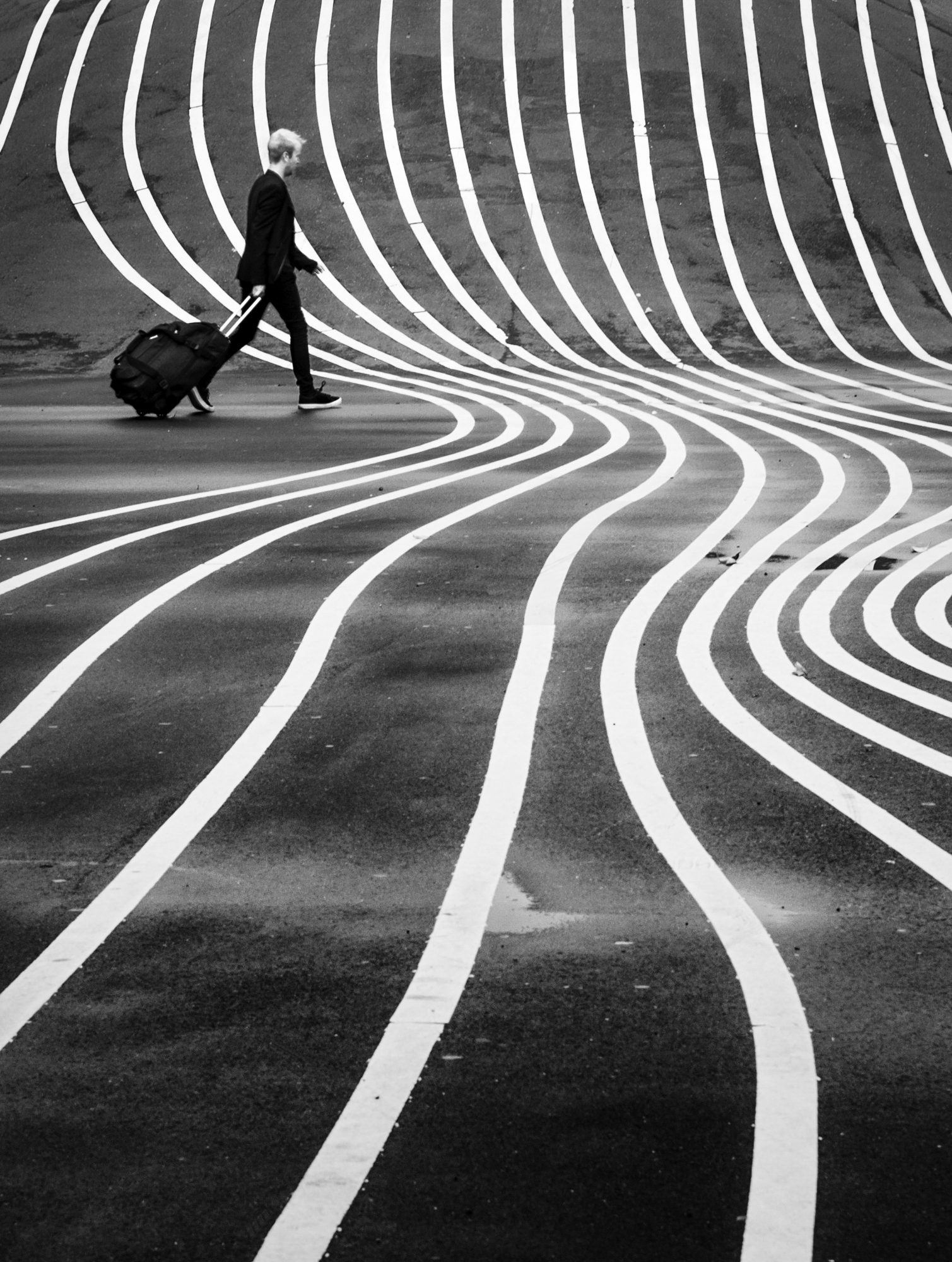 Leading lines composition of curved white road markings with a lone traveler