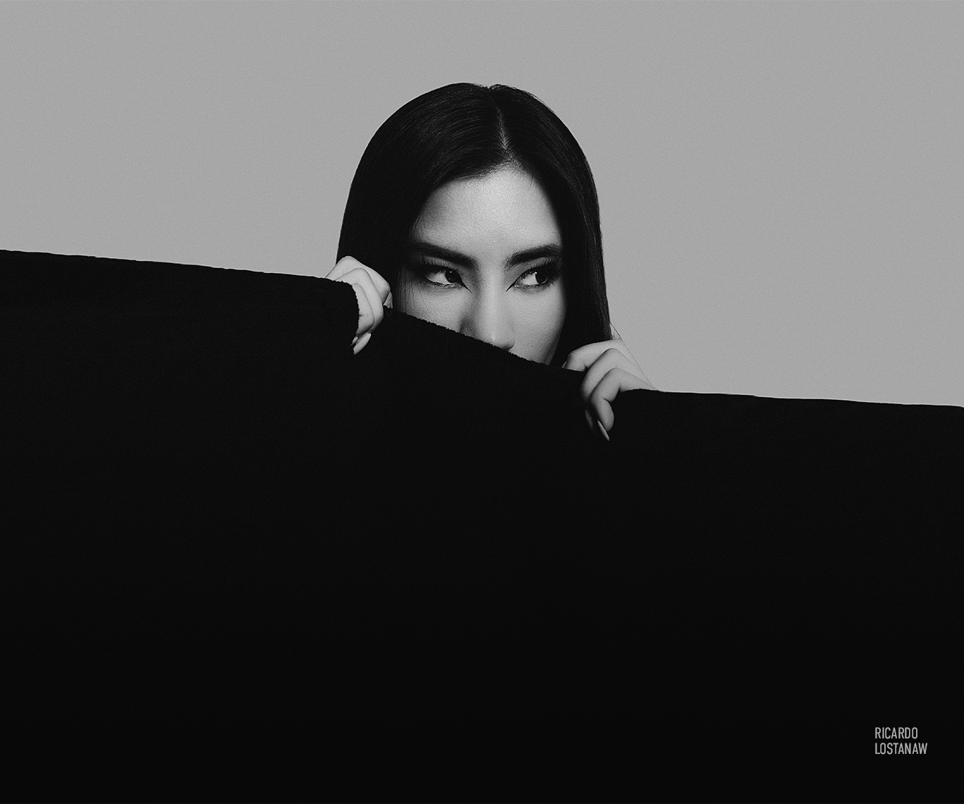 Woman's eyes appearing over a solid black shape, reduced to almost nothing