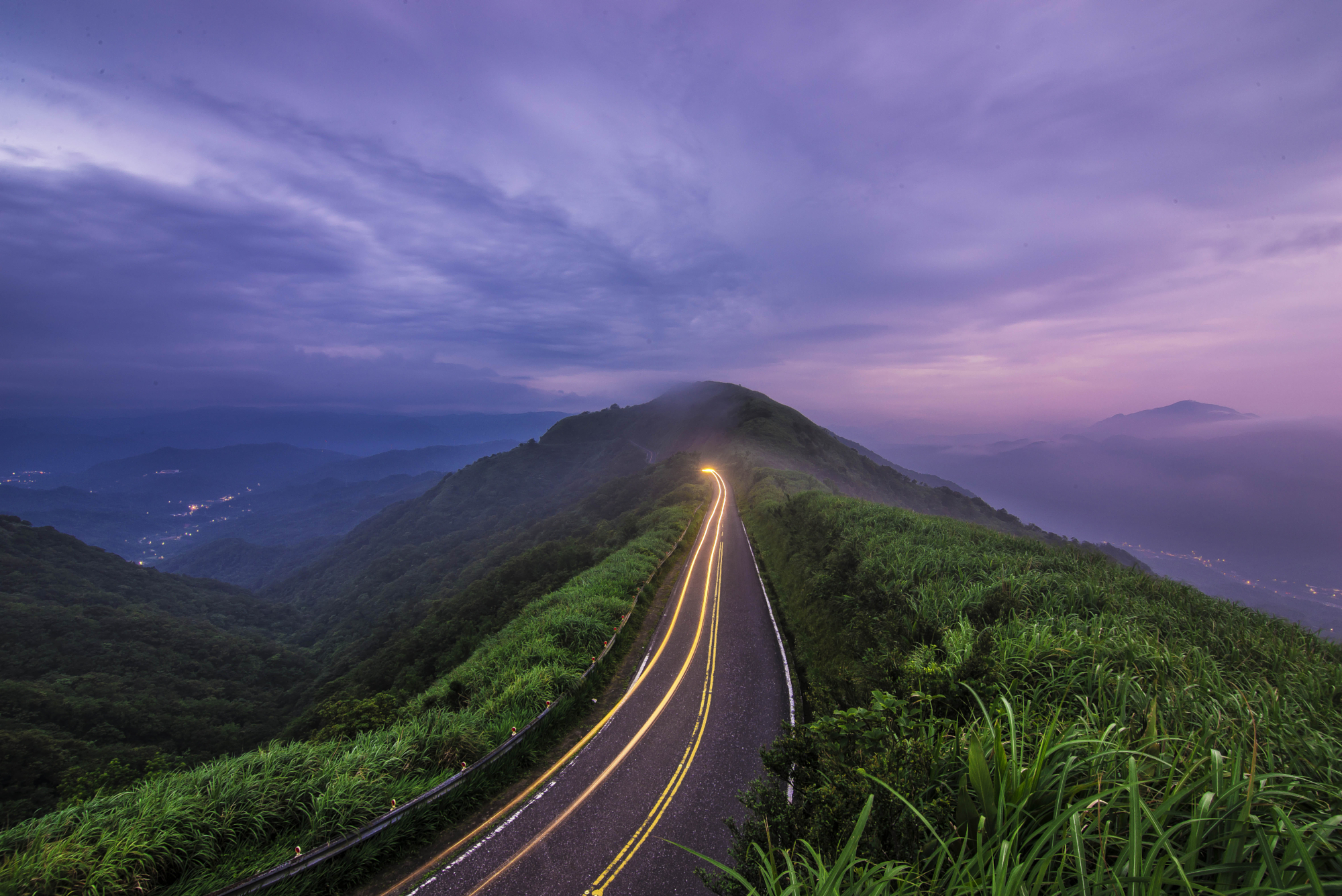 Long exposure night photography of car light trails on a winding mountain road in Taiwan by Gonzalo Bendito