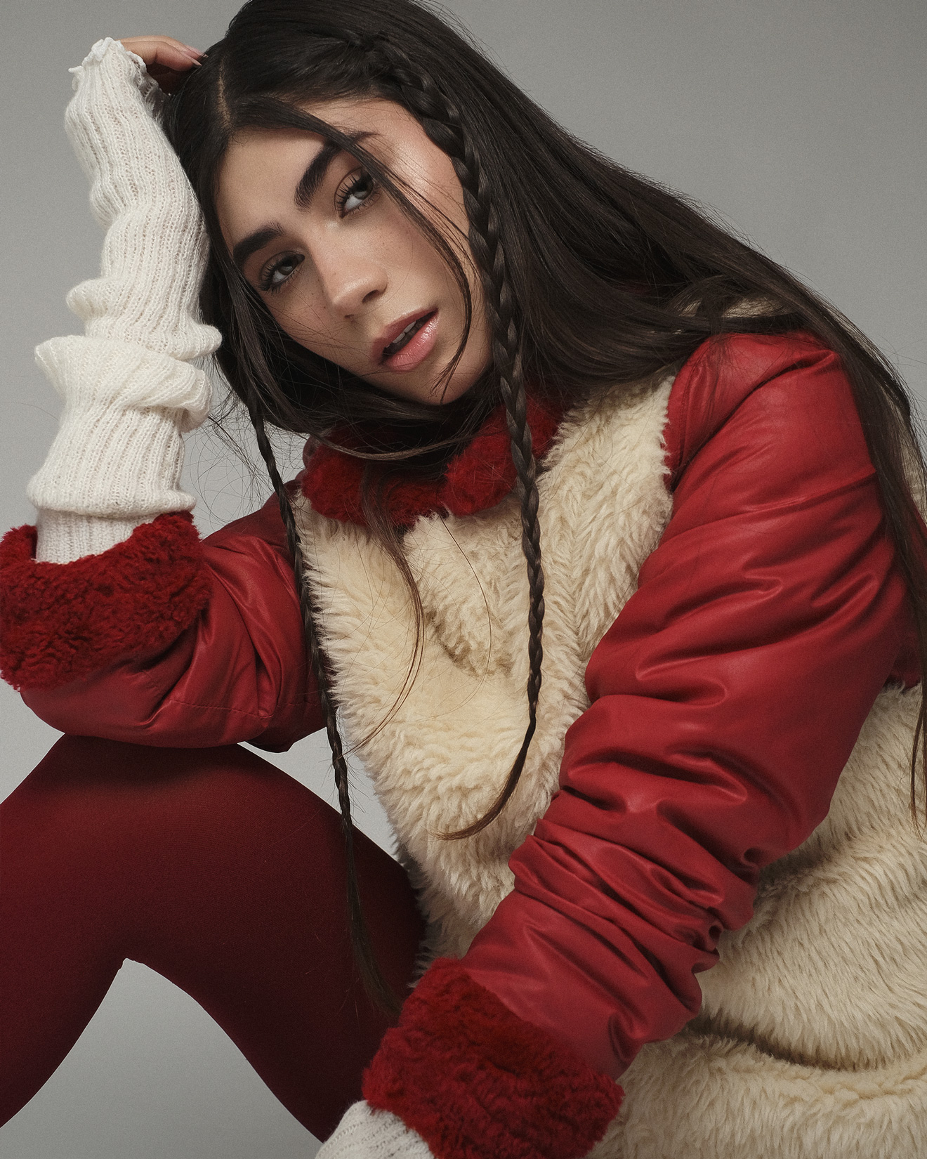 Studio portrait lighting on a model in red leather and cream shearling with long braids