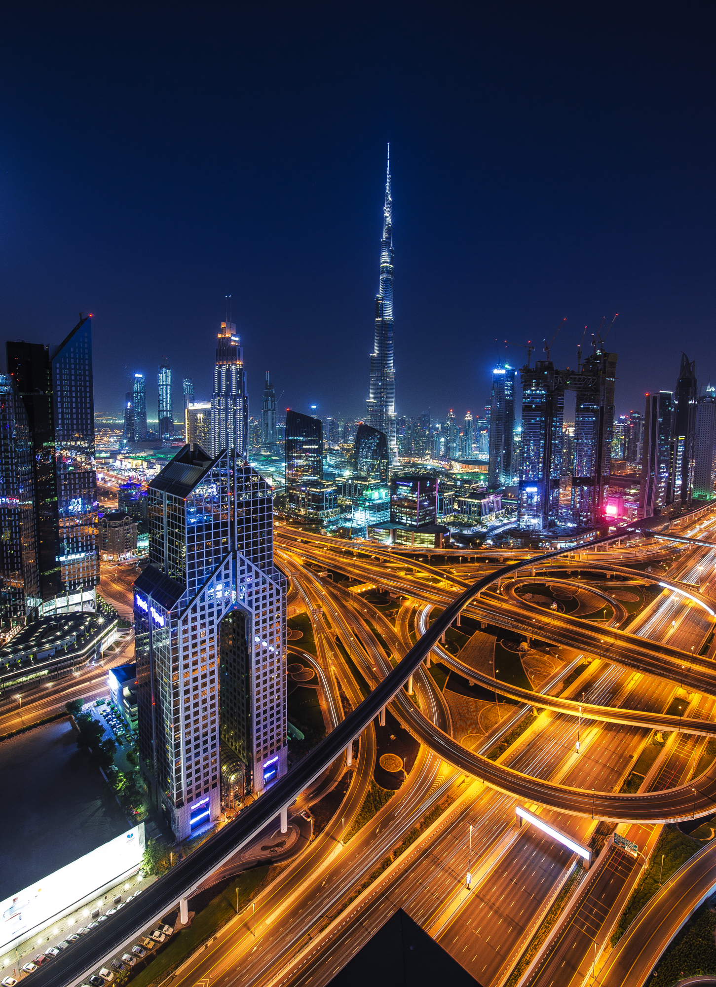 High angle long exposure night cityscape of Dubai featuring Burj Khalifa and glowing highway light trails, Gonzalo Bendito photography