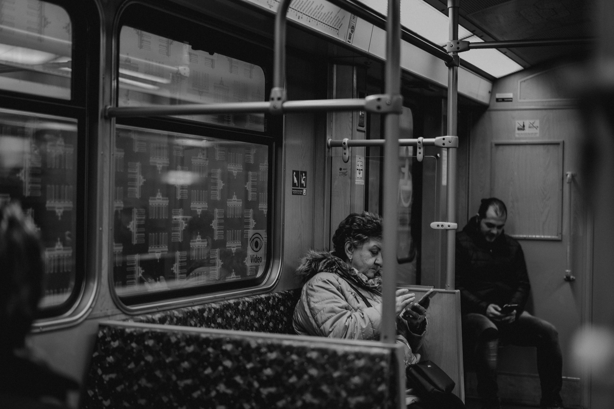 Woman on her phone in a near-empty metro carriage, a close-range frame from Eline Deckers's street photography.