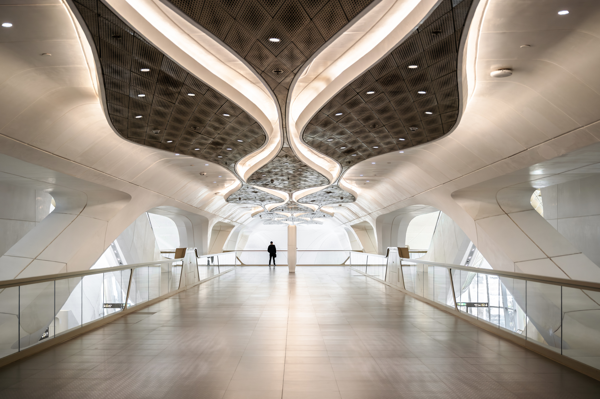 Wing-shaped coffered ceiling above an empty walkway inside KAFD Metro Station in Riyadh, from Andrew Shenouda's architectural photography.